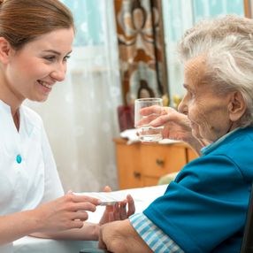 Eine junge Frau guckt freundlich zu einer älteren Dame